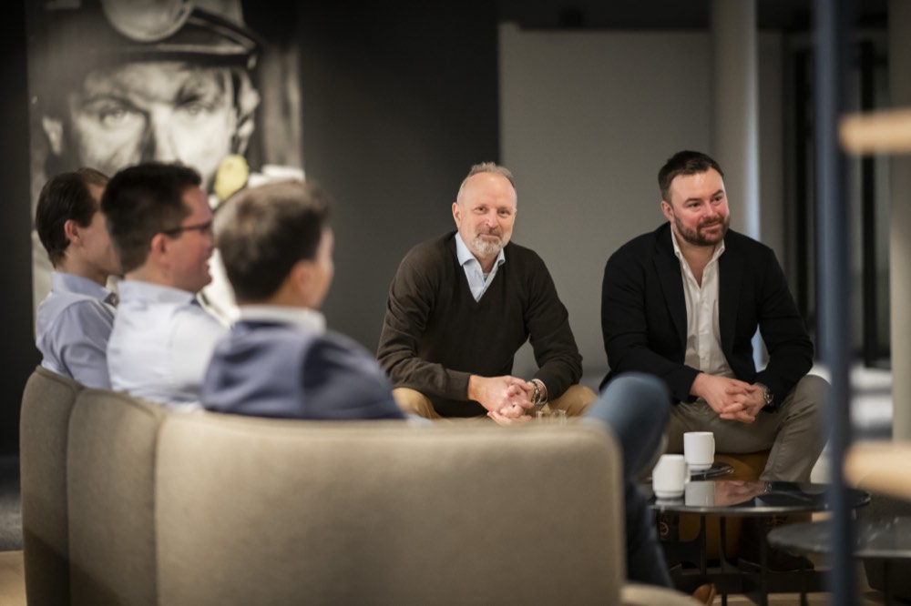 Fem kolleger i samtale rundt et bord